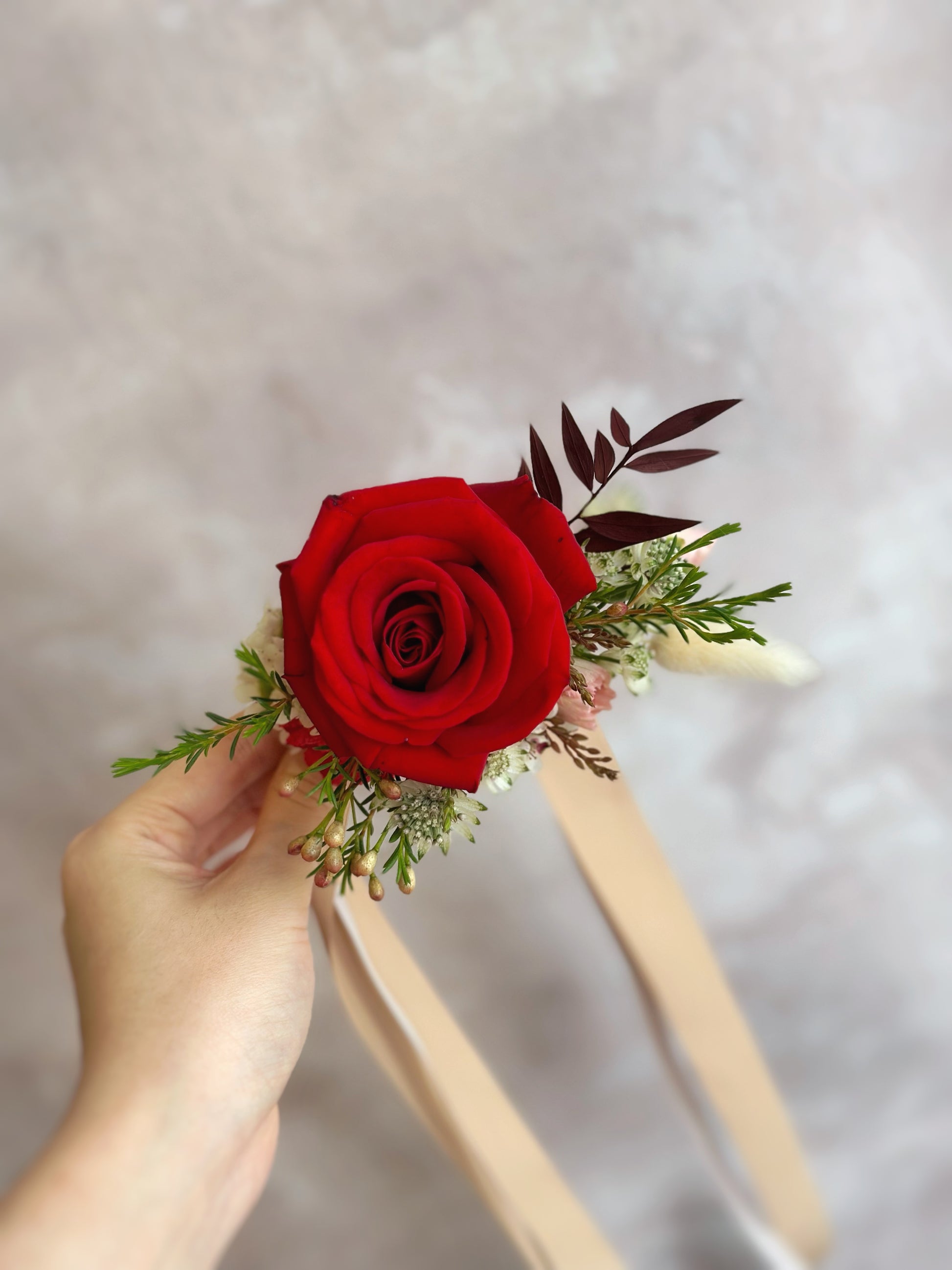  red roses wrist corsage with lush greeneries front view 