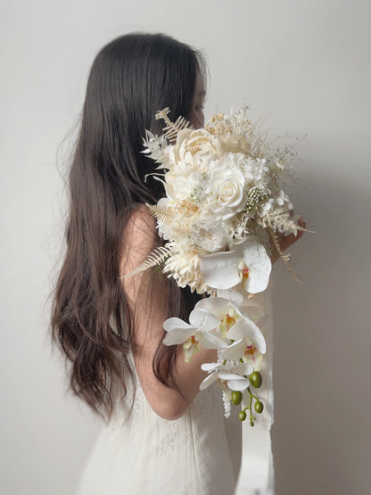 Elegant cascading preserved flowers bridal bouquet, adorned with a faux phalaenopsis orchid. 