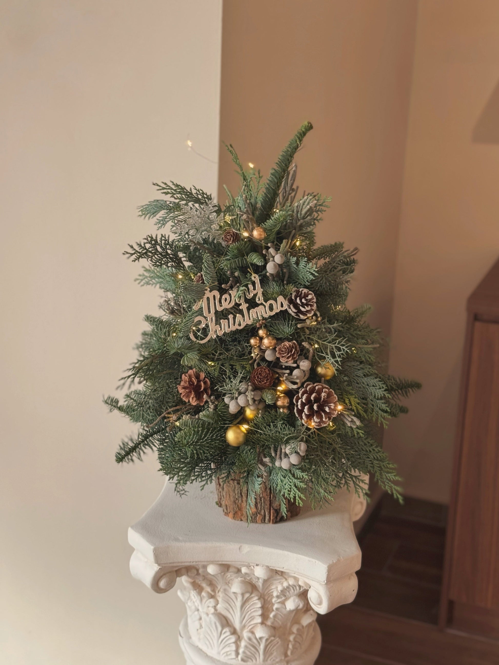 Woodland-inspired Christmas tree displayed as a rustic holiday décor piece with pinecones and gold accents.
森林风圣诞树，作为乡村风节日装饰陈列，搭配松果和金色点缀。