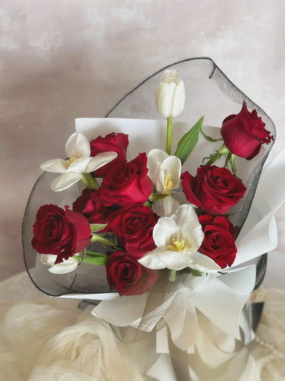 9 red roses mix with 5 stalks of white tulips, wrapped in white and black wrapper.