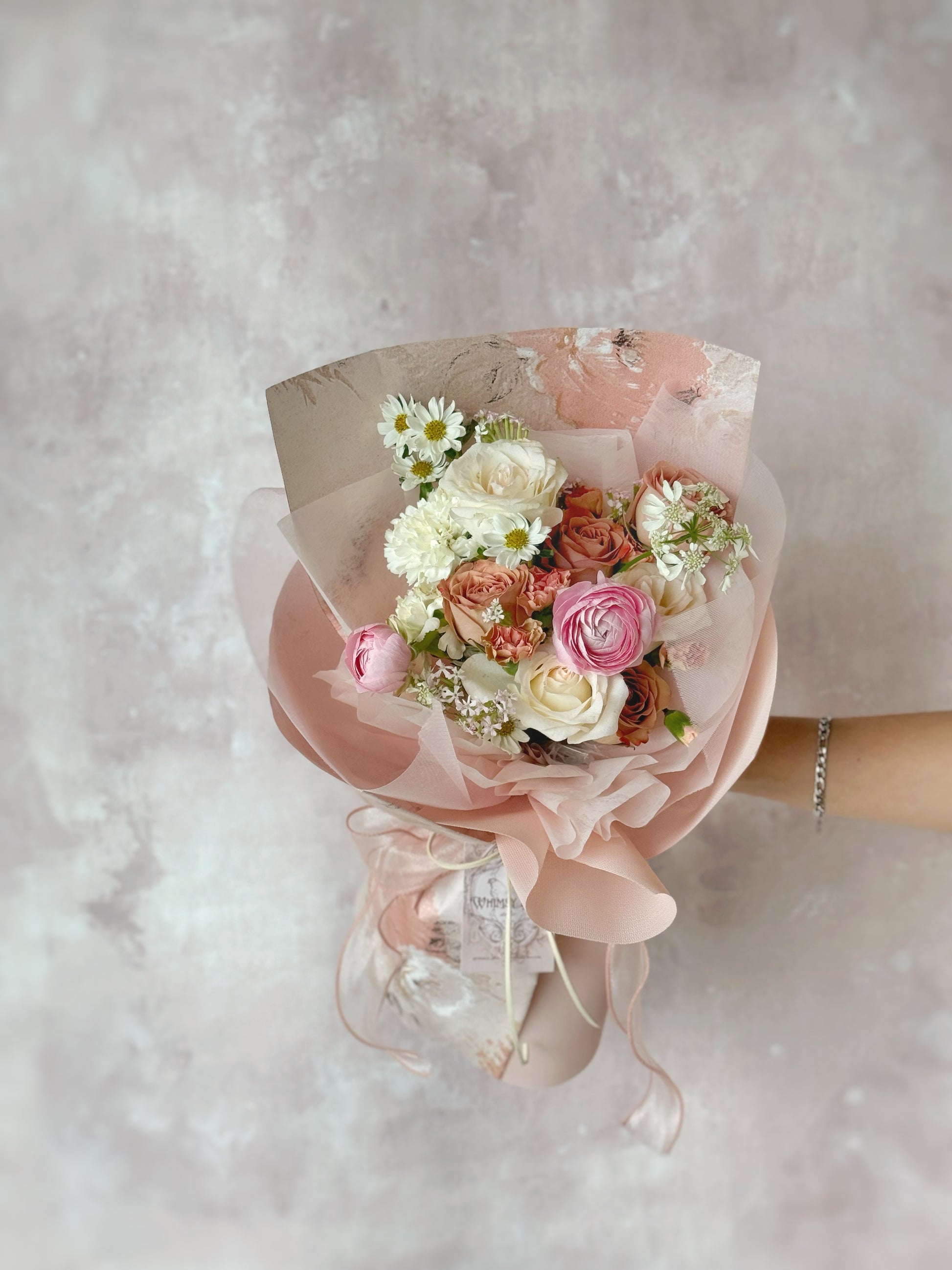  Close-up of delicate luxe size bouquet,  blush-toned petals and sheer ribbon, highlighting the subtle romantic touches.
中: 特写镜头呈现柔粉花瓣与薄纱蝴蝶结，细节尽显浪漫气息。