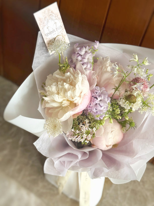  Close-up of creamy white peonies and hyacinth, lilac blooms, capturing petal texture and refined pastel tones.
米白芍药与淡紫花的特写，展现花瓣细节与优雅的浅色调。