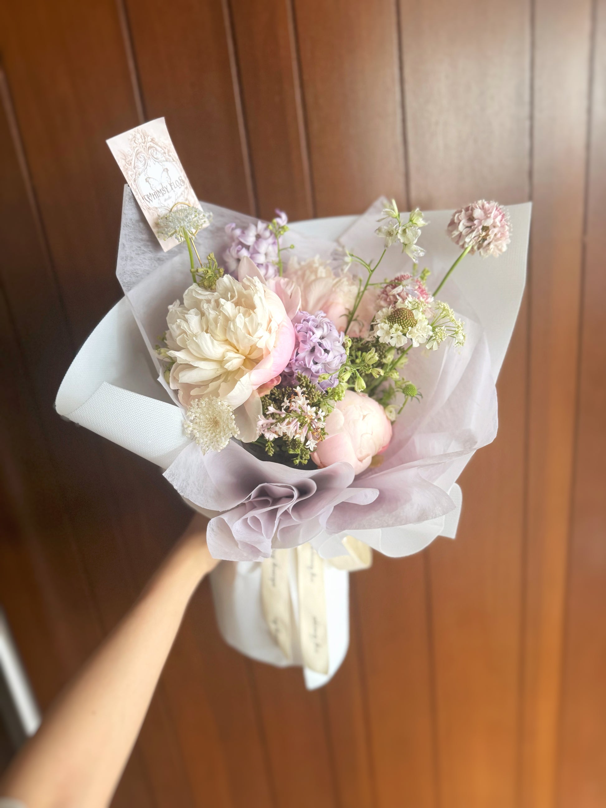  The pastel bouquet held in hand, radiating a soft and elegant moment of calm beauty.
手持淡色花束，捕捉静谧优雅的氛围感瞬间