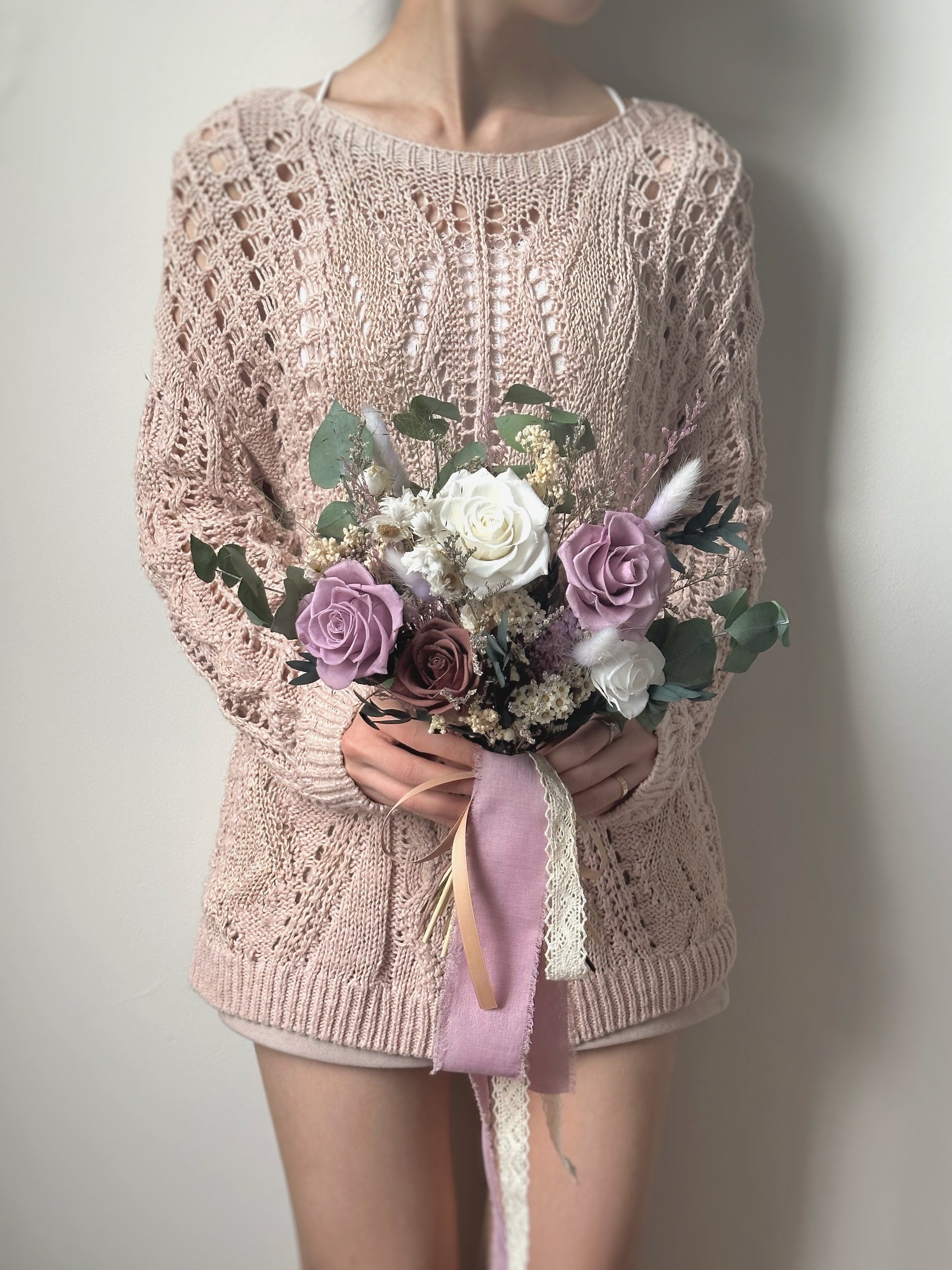 A bride holding the Lilac bouquet, its soft, fanned-out shape complementing a romantic garden wedding look.
新娘手持 Lilac 捧花，柔美的扇形设计完美契合浪漫花园婚礼风格。