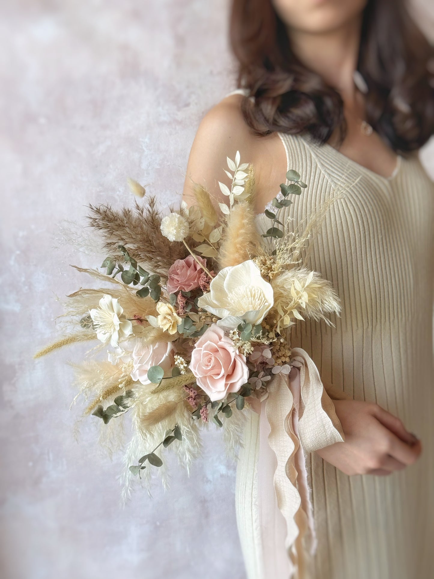 Linnea preserved flowers fan shaped bridal bouquet bohemian style , A side-angle view showcasing the bouquet’s structured yet airy composition, blending natural textures beautifully.
侧面视角展现捧花的立体感与蓬松层次，自然质感完美融合。