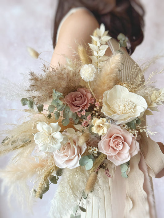 Linnea preserved flowers fan shaped bridal bouquet bohemian style holding by a model. The neutral tones complement any wedding dress, making it a timeless and versatile choice for a boho-chic wedding.
大地色系适配任何婚纱，波西米亚风格经典百搭