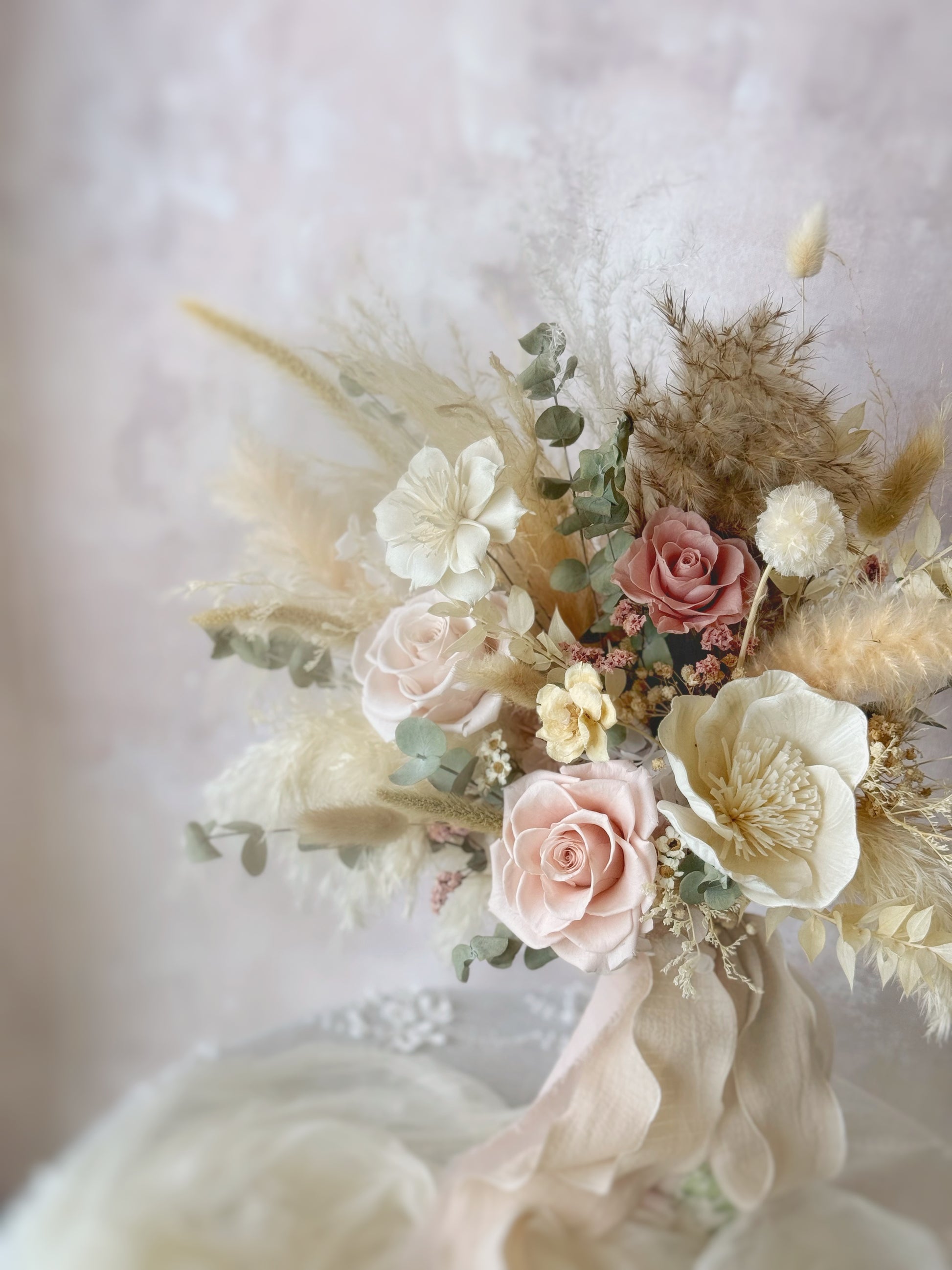 The relaxed, bohemian-style bouquet rests elegantly on a table, showcasing its natural textures and warm hues.
波西米亚风捧花静置桌上，自然的质感与温暖色调尽显优雅气息。