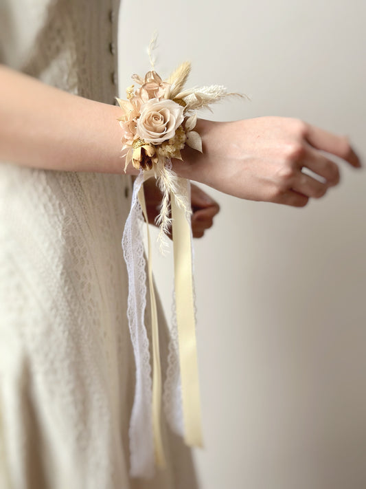 Close-up of a model wearing a lace-adorned Champagne-toned everlasting rose wrist corsage, showcasing its elegant and timeless design.