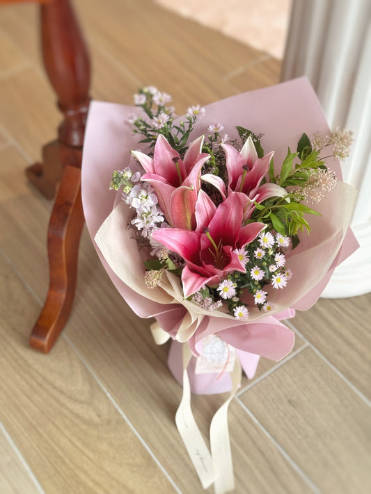 Top-down view revealing a harmonious blend of bold pink lilies and soft-toned fillers arranged symmetrically.
 俯视图展现粉色百合与柔色配花的协调搭配，整体布局对称、层次丰富。