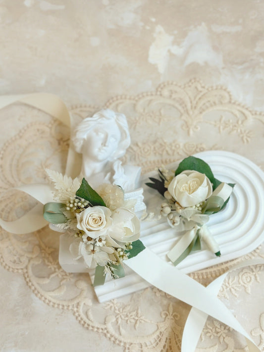 Top view of Midori preserve/sola flowers wrist corsage and boutonniere in green and white tone. Perfect for a garden theme wedding 