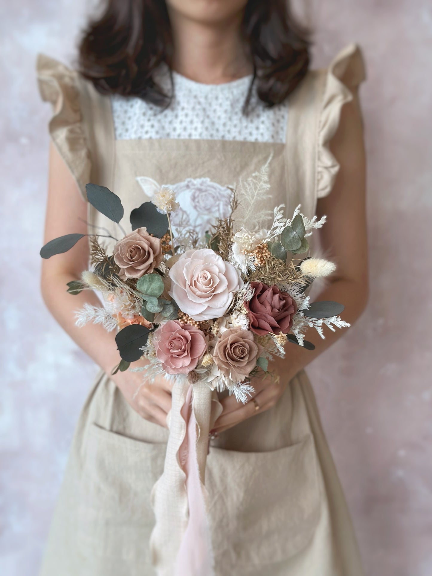 The bride holds the fan-shaped preserved bouquet, its earthy tones enhancing the effortless, bohemian charm.
新娘手捧扇形永生花捧花，大地色调彰显随性波西米亚风格。