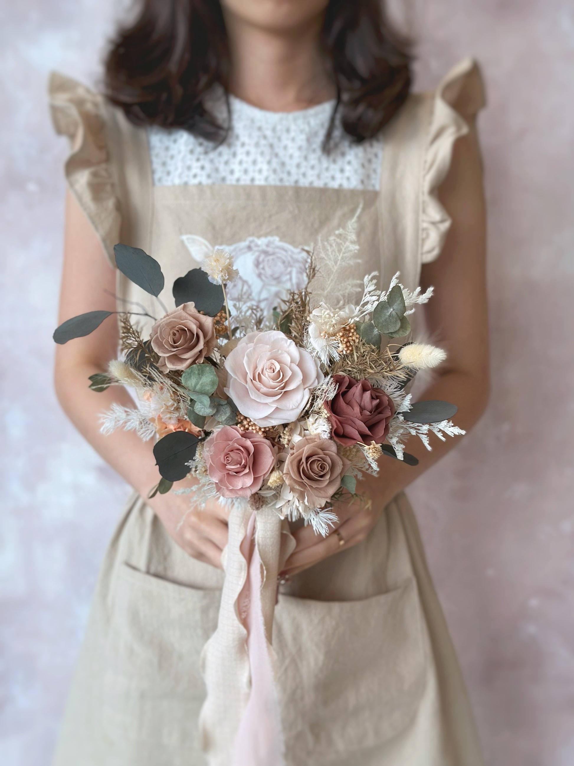 The bride holds the fan-shaped preserved bouquet, its earthy tones enhancing the effortless, bohemian charm.
新娘手捧扇形永生花捧花，大地色调彰显随性波西米亚风格。