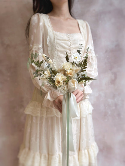 A bride holding the Myrtle bouquet, its delicate, cascading shape adding an ethereal, natural touch.
新娘手持 Myrtle 捧花，其细腻的层次和自然下垂感增添仙气。