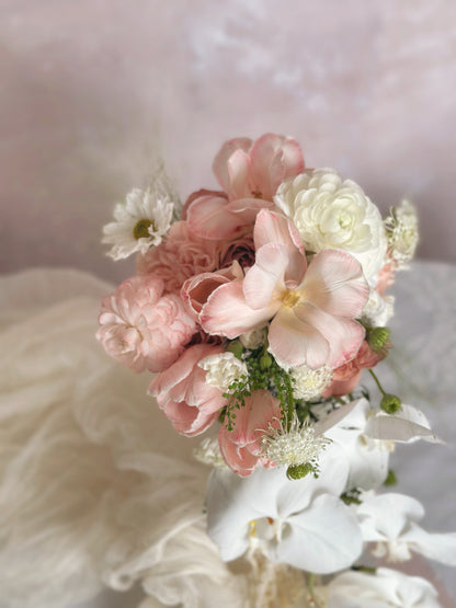 Elegant peach roses, blush florals, and soft greenery designed in a cascading bouquet
蜜桃粉玫瑰、裸粉花朵与柔和绿叶交织，打造优雅垂坠式捧花