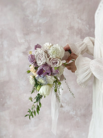 A romantic teardrop bouquet with flowing orchids, held by a bride for a graceful and sophisticated wedding aesthetic
新娘手持 Ocean Eyes 捧花，流畅线条尽显高贵优雅


