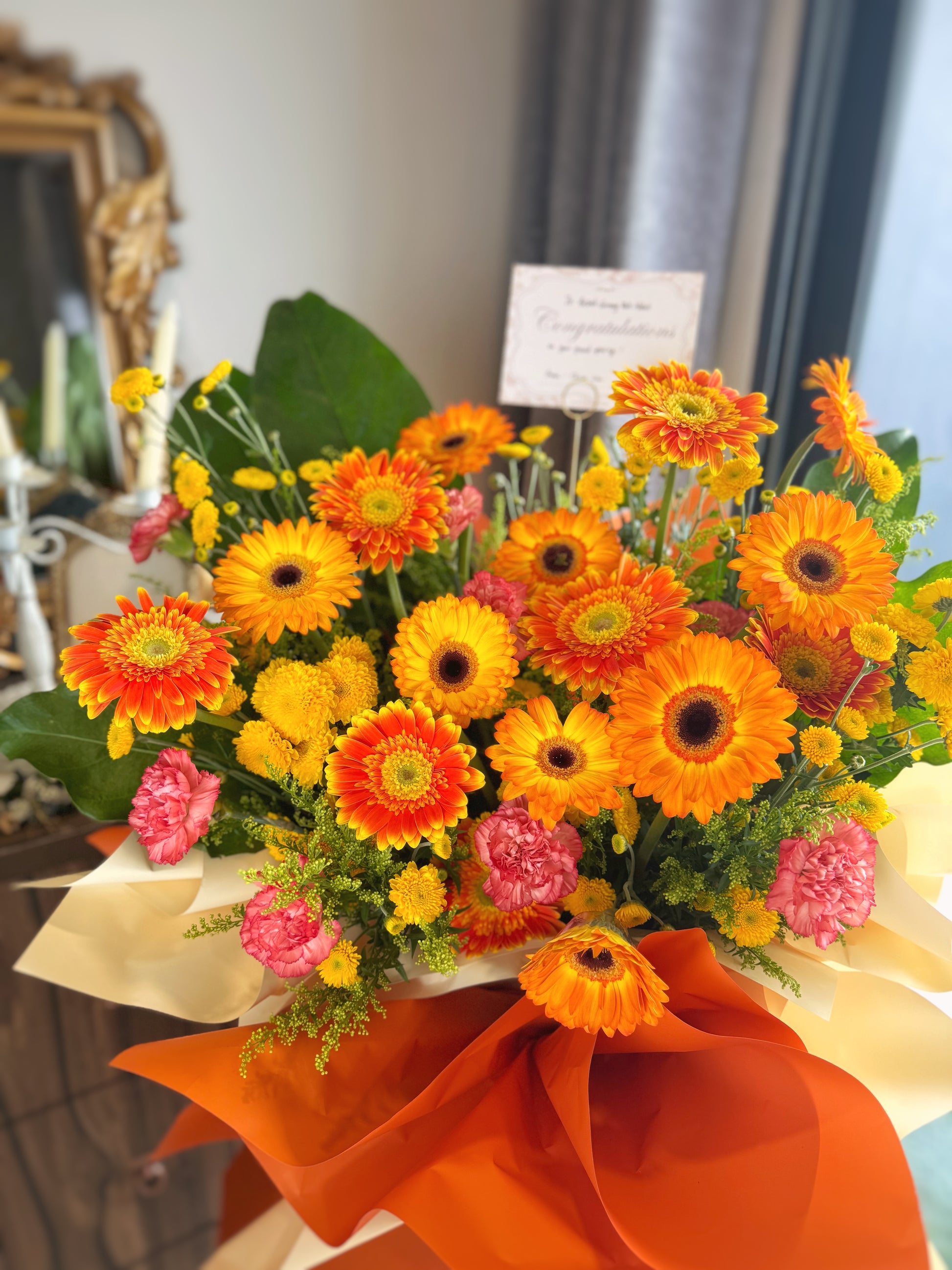 Vibrant grand opening stand showcasing bright orange and yellow gerberas in a cheerful arrangement, symbolizing energy, joy, and success