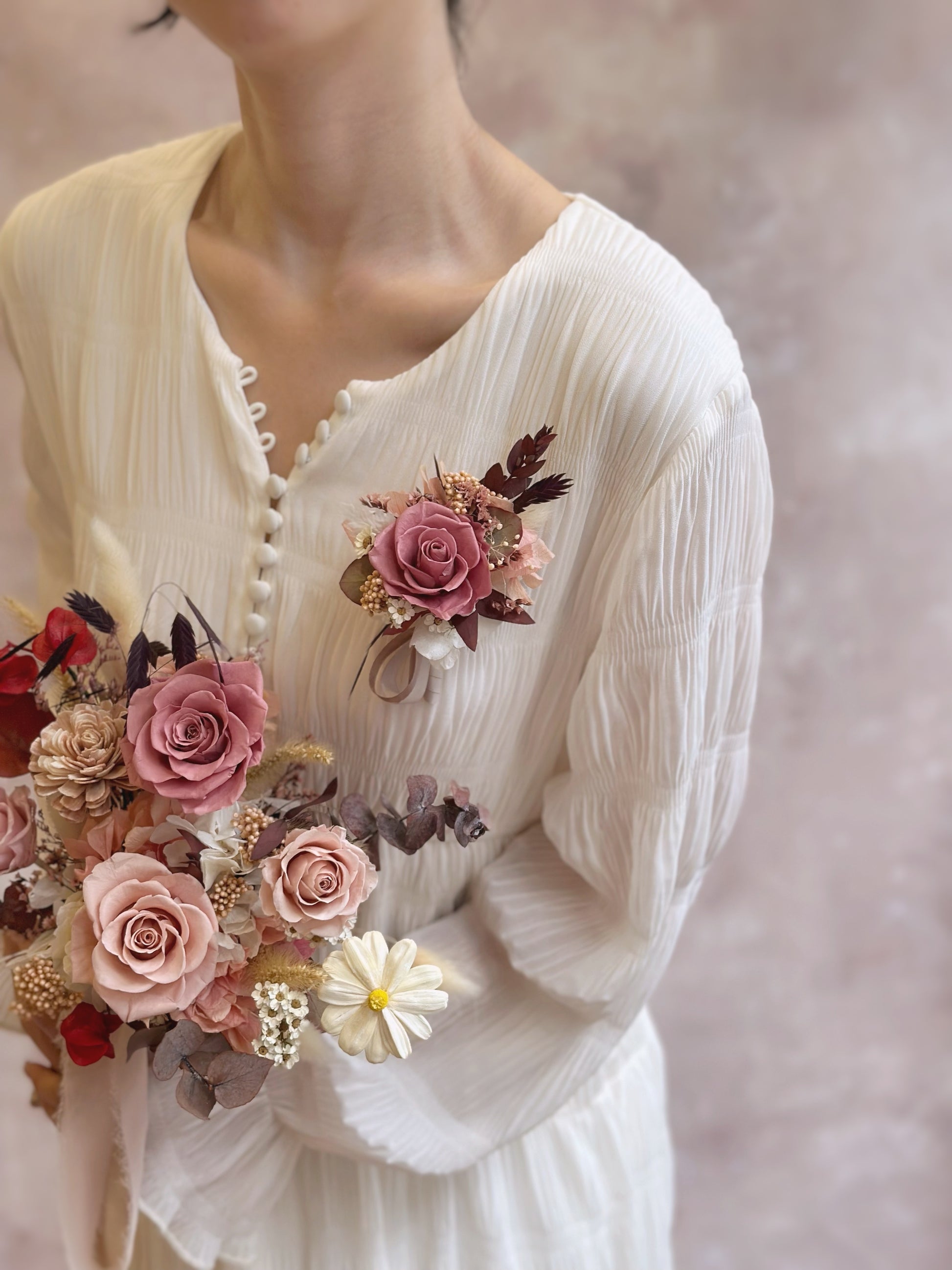Model elegantly holding the matching bouquet while wearing the matching Primrose corsage, showcasing a harmonious floral design.
