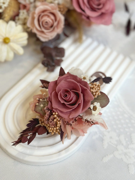 top view of primrose preserved rose corsage, showcasing its nude pink and burgundy tone