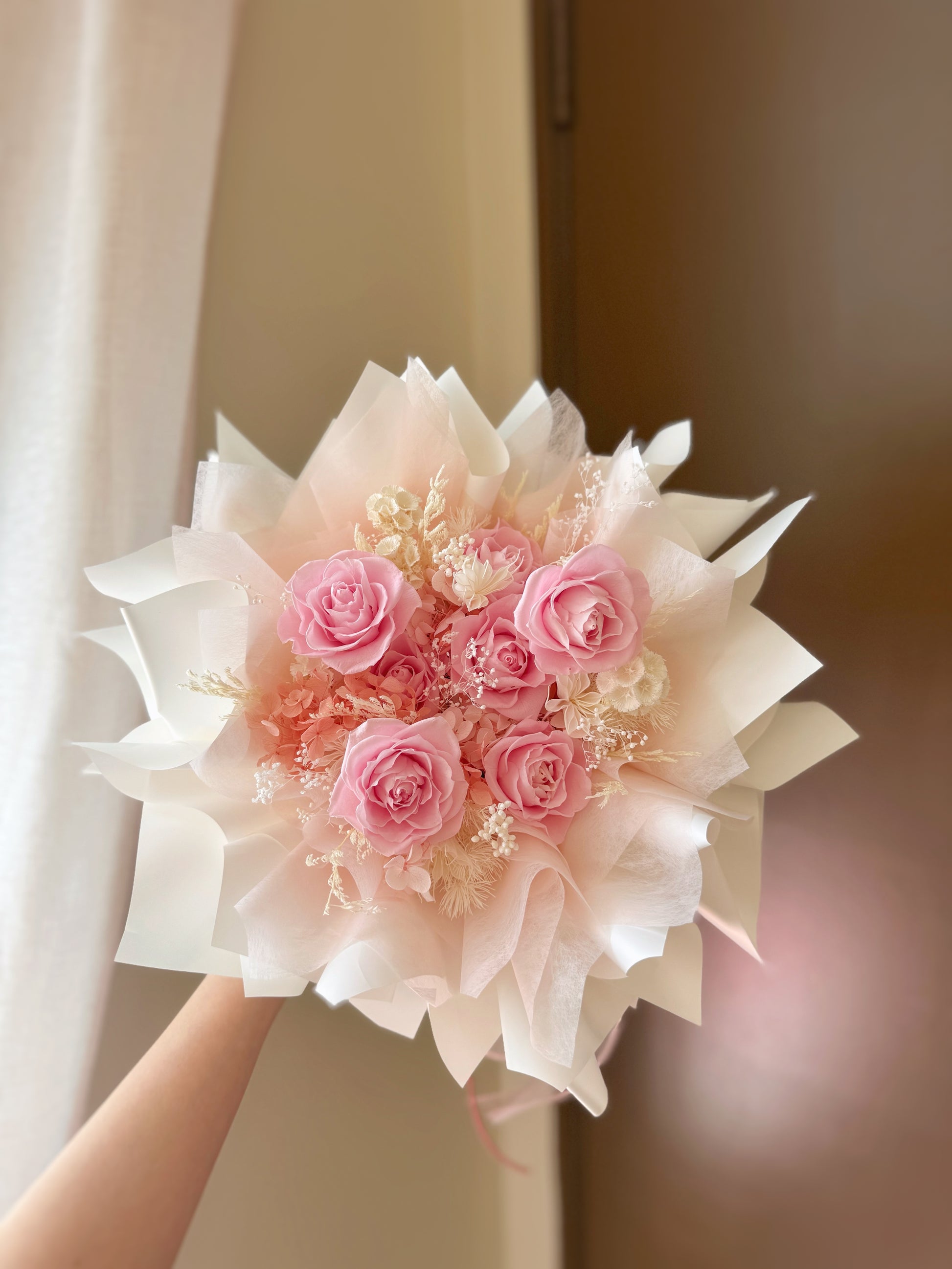The “Rosie Nest” preserved flower bouquet held by hand, showing its cozy, rounded nest shape and natural color palette. A soft and thoughtful gift arrangement.
手拿“Rosie Nest”永生花束，展现其温柔巢形结构与自然配色，是一份温馨有心思的花礼。