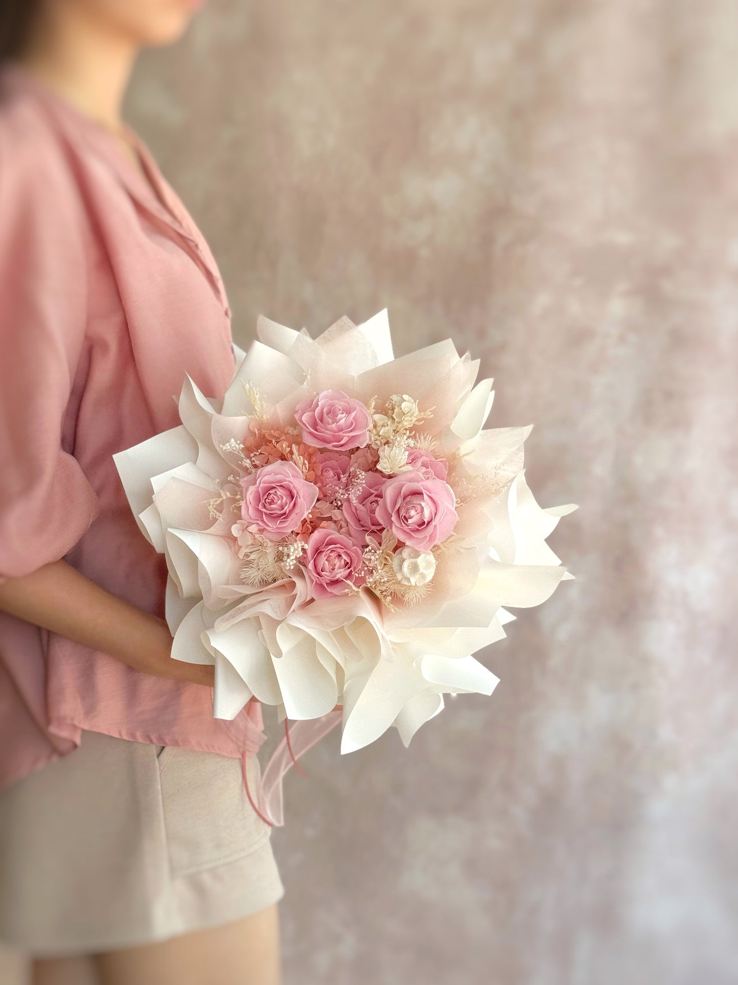A side view of the “Rosie Nest” preserved flower bouquet, showcasing its rounded, nest-like shape and soft layers of preserved blooms in warm pink, nude, and earthy tones.
“Rosie Nest”永生花束的侧面图，展现其巢形的圆润结构，以及温柔层次的粉色、裸色与大地色调花材。