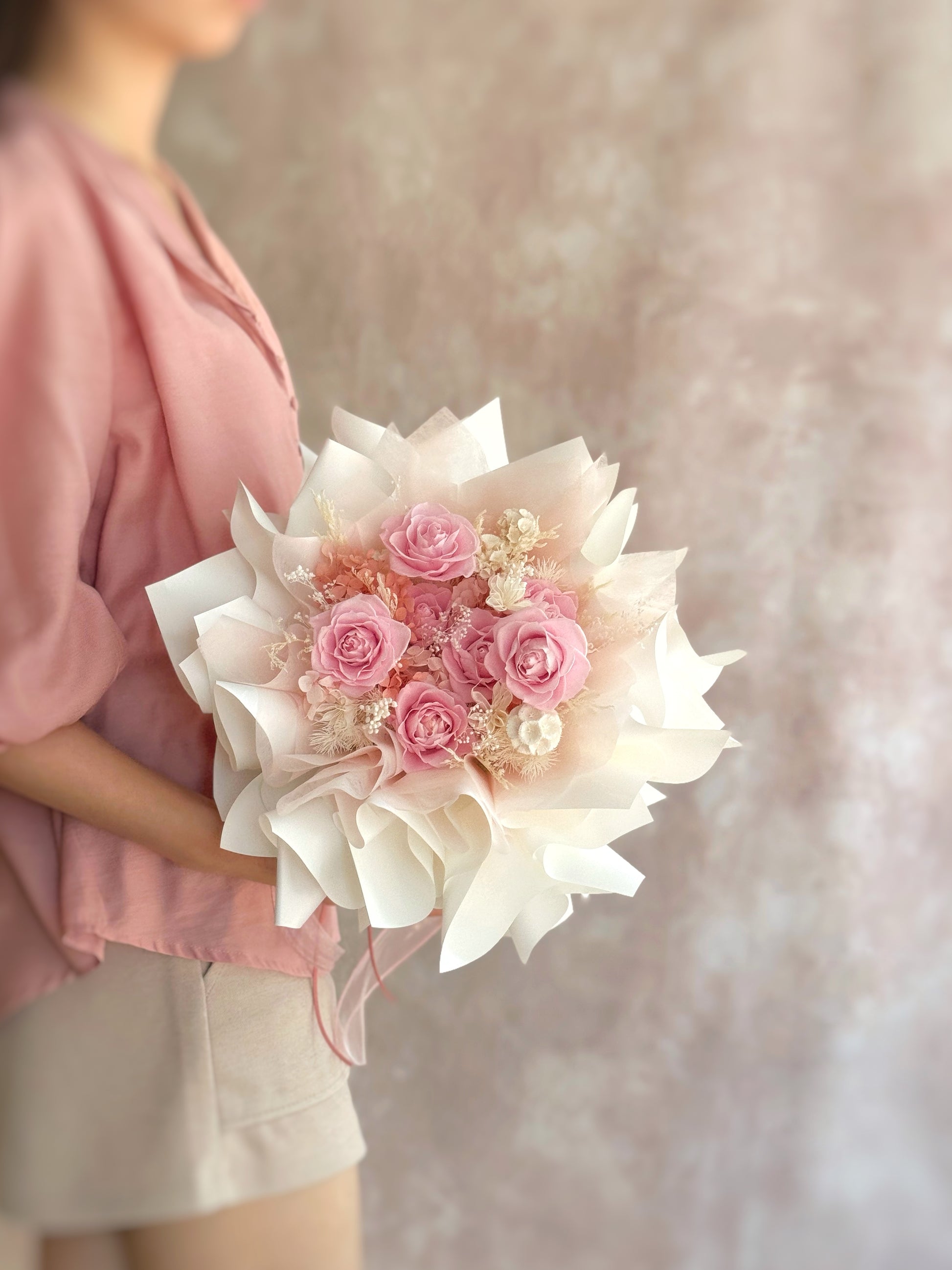 A side view of the “Rosie Nest” preserved flower bouquet, showcasing its rounded, nest-like shape and soft layers of preserved blooms in warm pink, nude, and earthy tones.
“Rosie Nest”永生花束的侧面图，展现其巢形的圆润结构，以及温柔层次的粉色、裸色与大地色调花材。