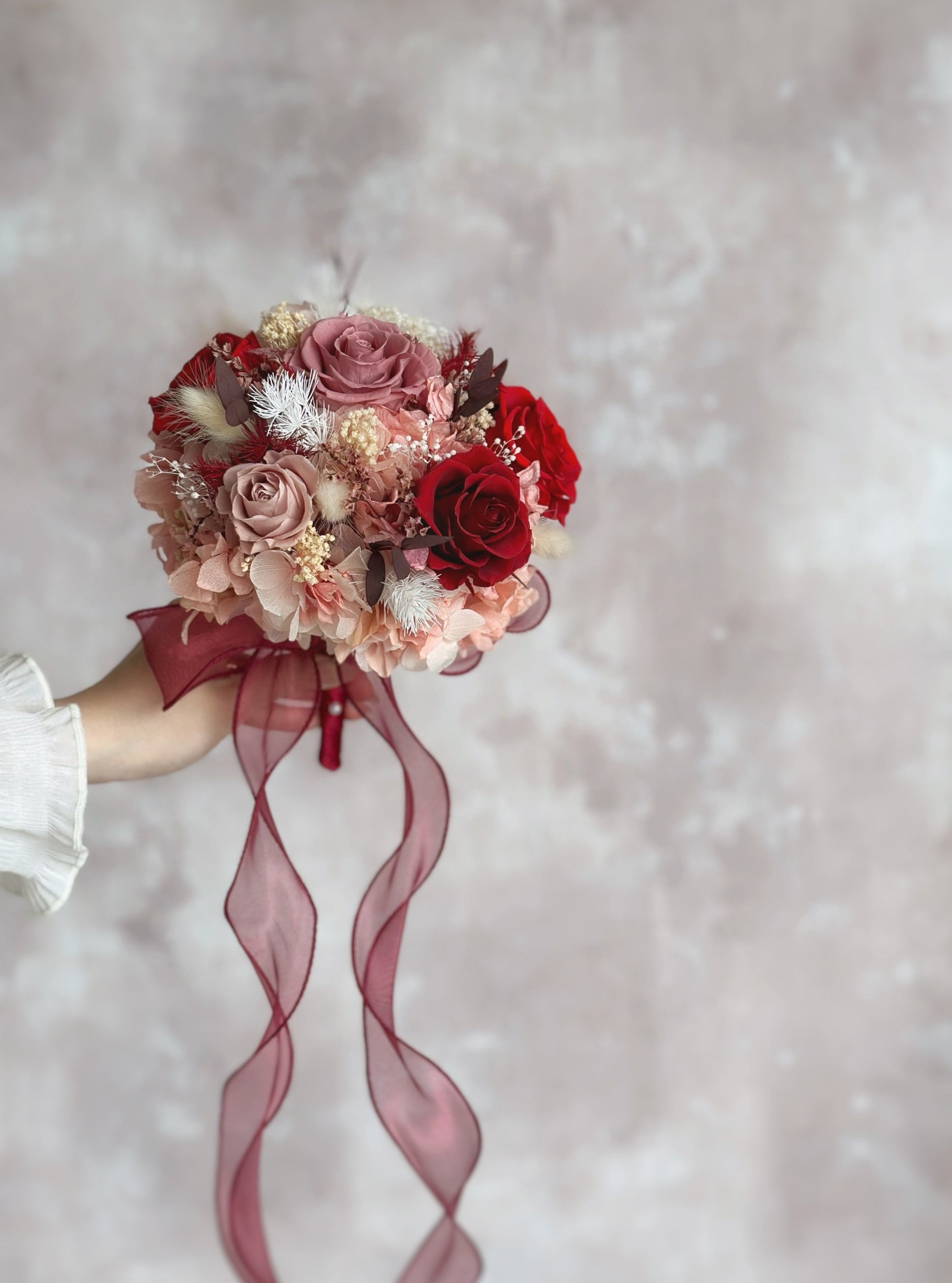 A side view of the bouquet, highlighting the beautifully arranged preserved roses and textured fillers.
捧花侧视图，展现精致排列的永生玫瑰与丰富层次感。