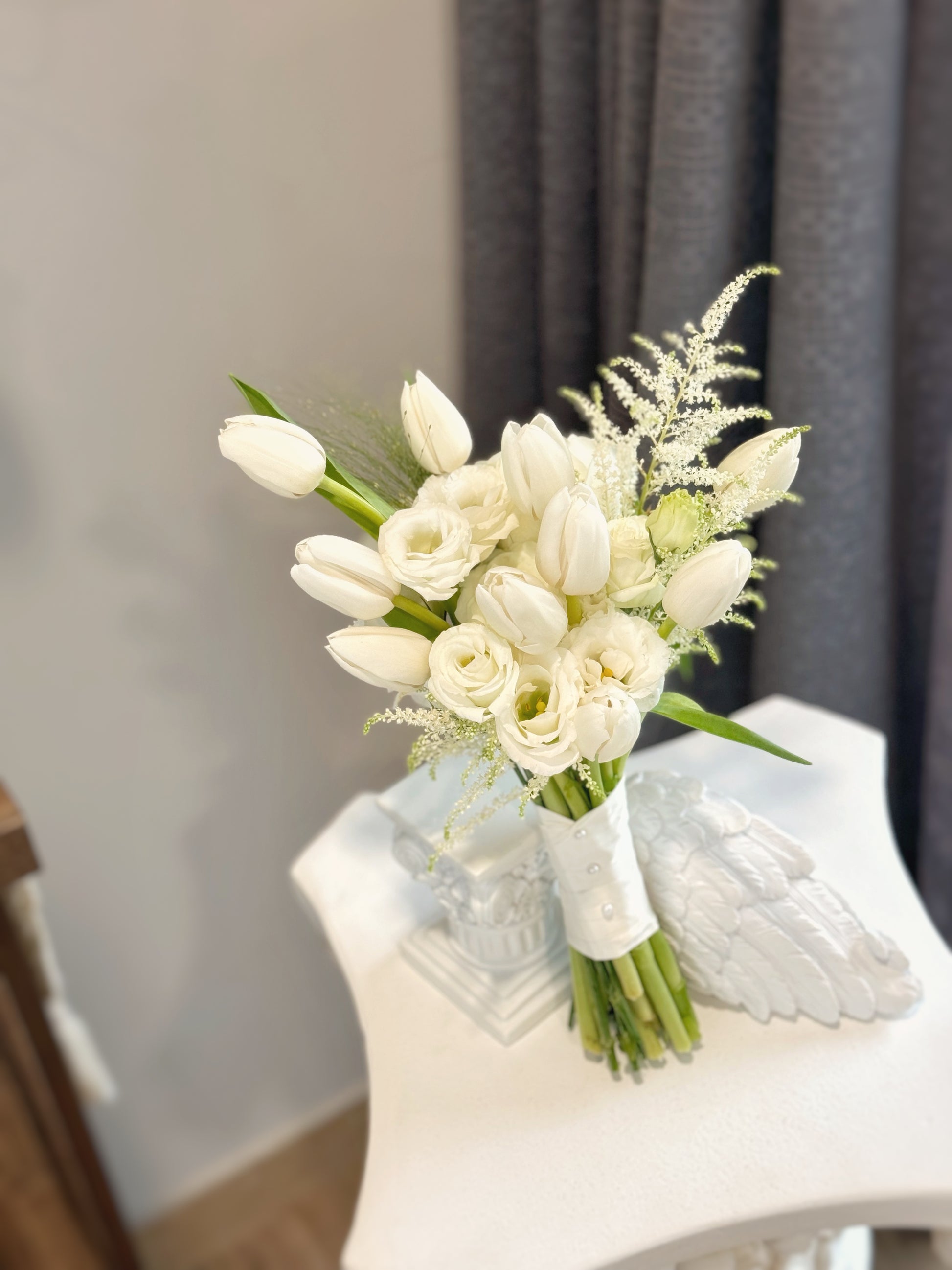 A delicate close-up of the bouquet’s premium white flowers, highlighting the soft textures of tulips, eustoma, and astilbe.
近距离拍摄高级感白色花材，突显郁金香、洋桔梗和络新妇的柔美质感。