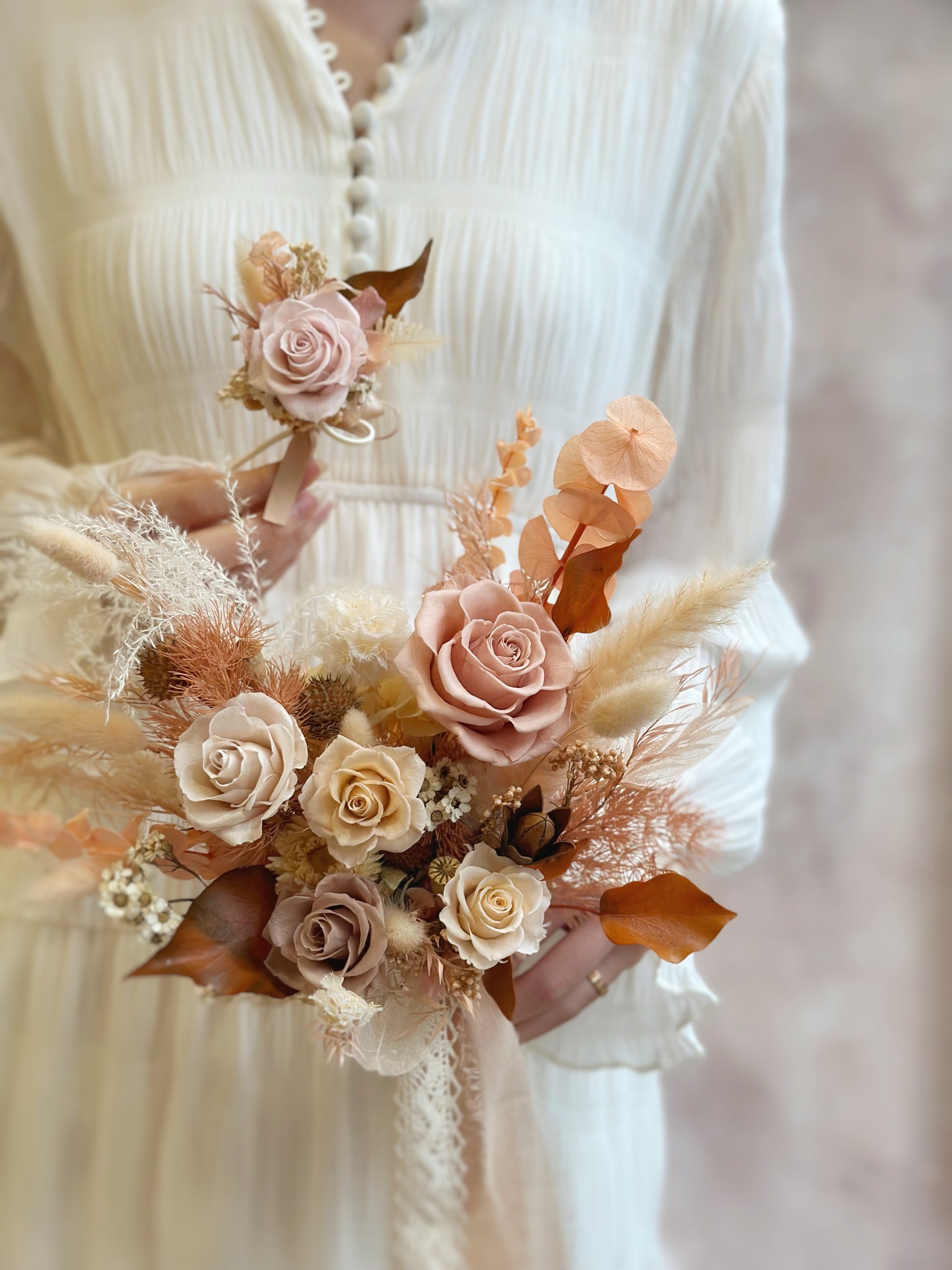 A preserved flower corsage featuring warm neutral hues, designed to pair seamlessly with the bridal bouquet.
一款暖色系永生花胸花，与新娘捧花完美搭配。
