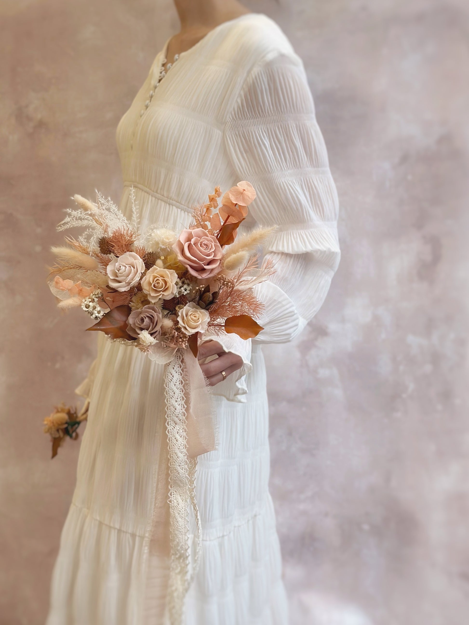 A perfectly balanced bouquet with rich autumnal hues, adding warmth and elegance to the wedding ensemble.
色调丰富的秋日捧花，为婚礼造型增添温暖与优雅