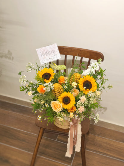zoomed out view of sunflowers mix bloom box on a wooden chair