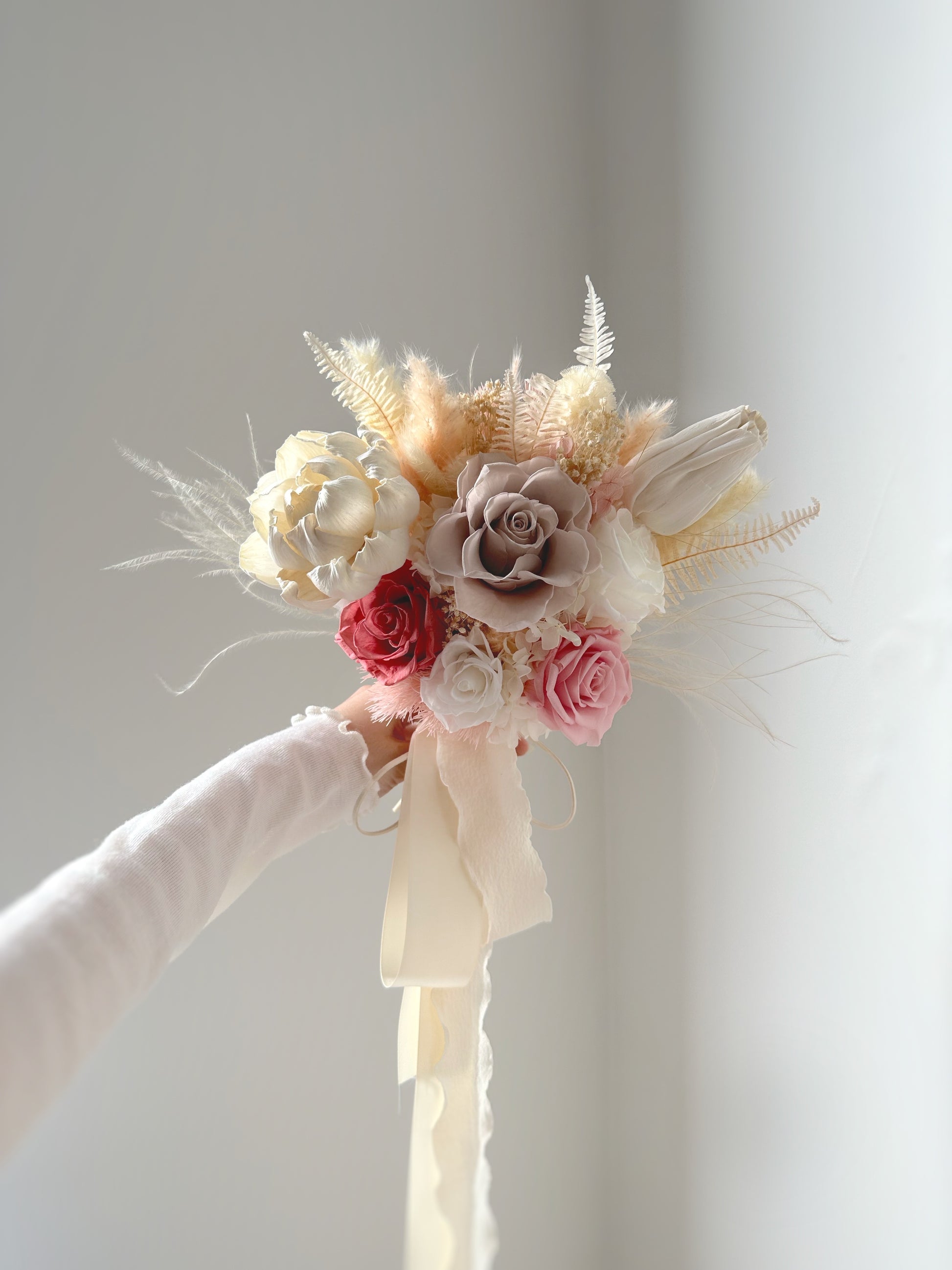The bouquet’s airy design flows naturally, complementing an elegant and romantic bridal aesthetic.
捧花的轻盈设计自然垂落，与优雅浪漫的新娘造型完美契合。

