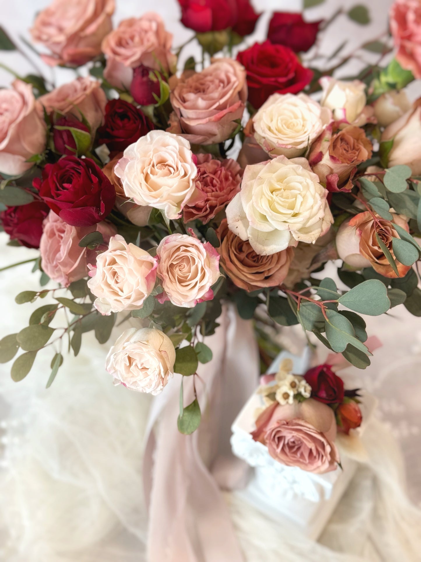 A loose garden-style bouquet with a matching wrist corsage, featuring maroon and dusty pink tones
自然花园风捧花，搭配手腕花，呈现酒红与尘粉色调的和谐搭配