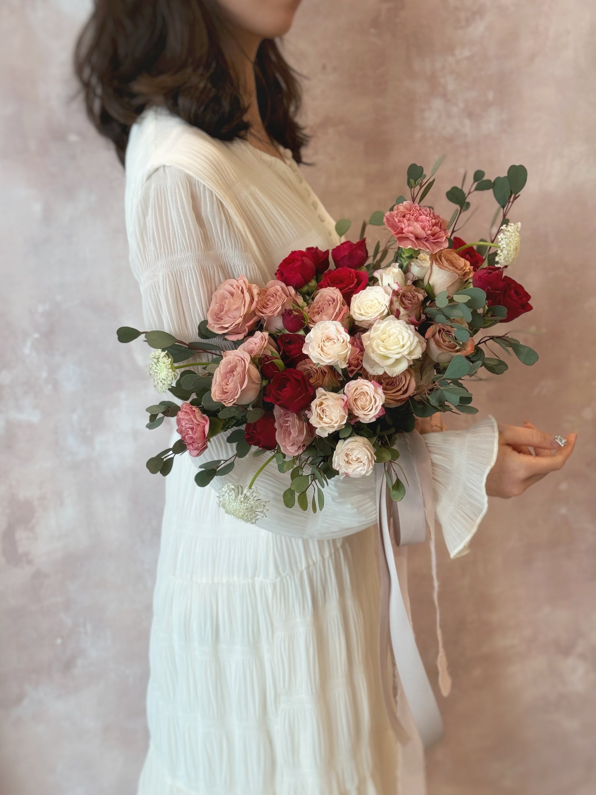 A natural, loosely gathered rose bouquet with eucalyptus, ideal for rustic and vintage weddings
采用自然随性搭配的玫瑰捧花，点缀尤加利叶，适合田园复古婚礼