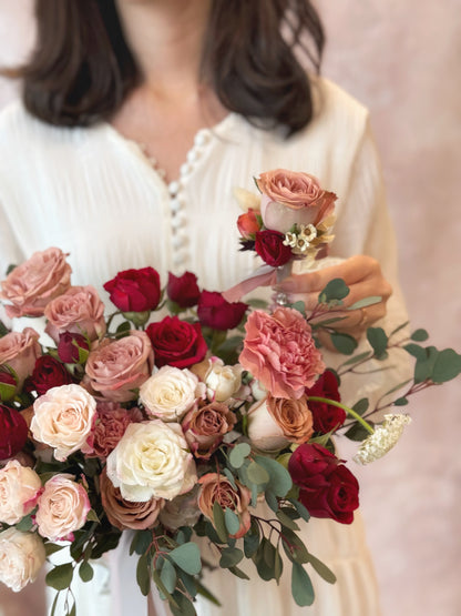 The bride’s lush rose bouquet and the groom’s boutonniere, a romantic floral pairing for the perfect wedding look
新娘丰盈玫瑰捧花与新郎胸花，浪漫花艺组合，成就完美婚礼造型
