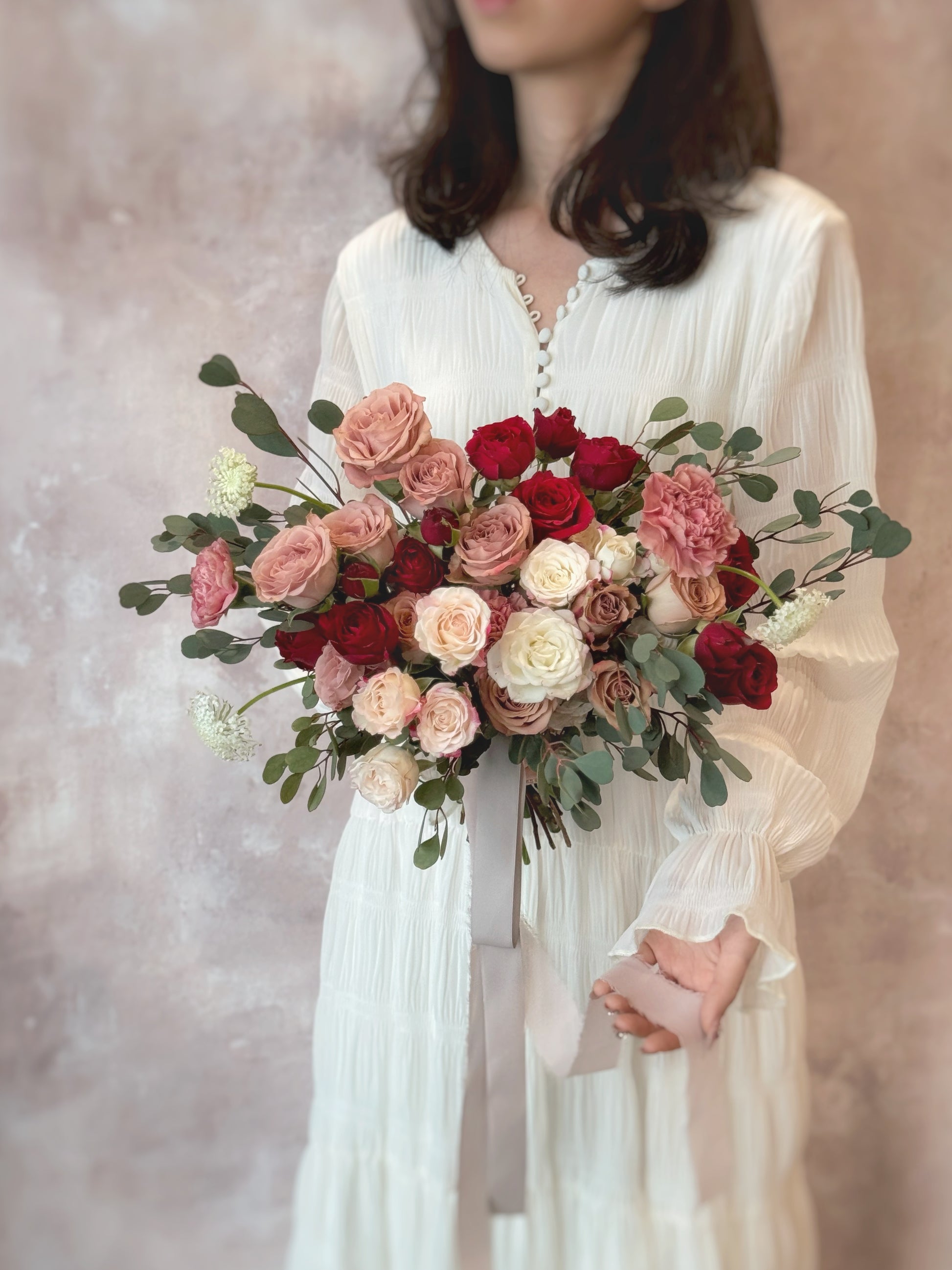 oft layers of maroon and dusty pink roses intertwined with eucalyptus, creating a dreamy floral composition
酒红与尘粉玫瑰交错叠加，搭配尤加利叶，营造梦幻花艺层次

