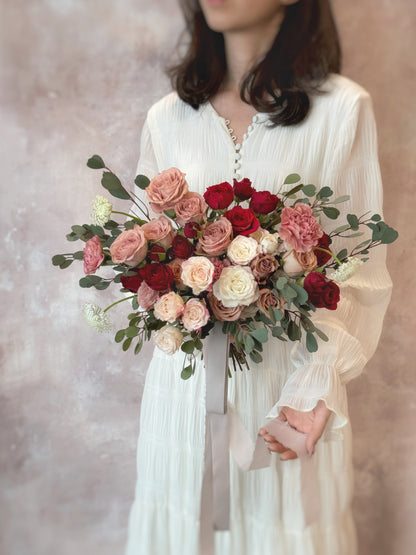 oft layers of maroon and dusty pink roses intertwined with eucalyptus, creating a dreamy floral composition
酒红与尘粉玫瑰交错叠加，搭配尤加利叶，营造梦幻花艺层次

