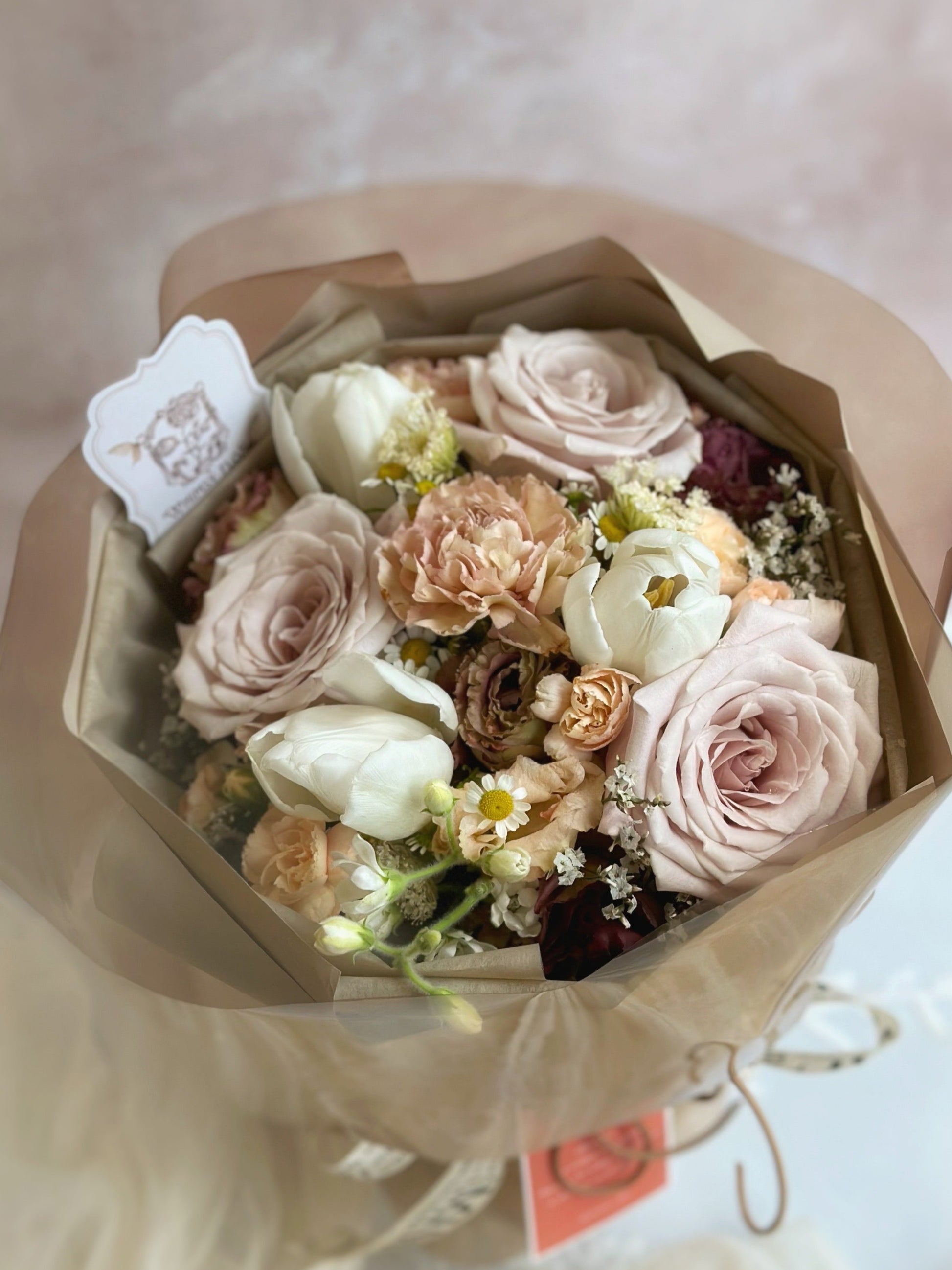 Close-up of the bouquet’s soft-toned flowers in beige, taupe, and blush, highlighting their delicate texture and moody vintage hues.
 特写镜头展示米色、灰褐与裸粉色花朵的细腻质感，呈现柔和而带情绪感的复古色彩。