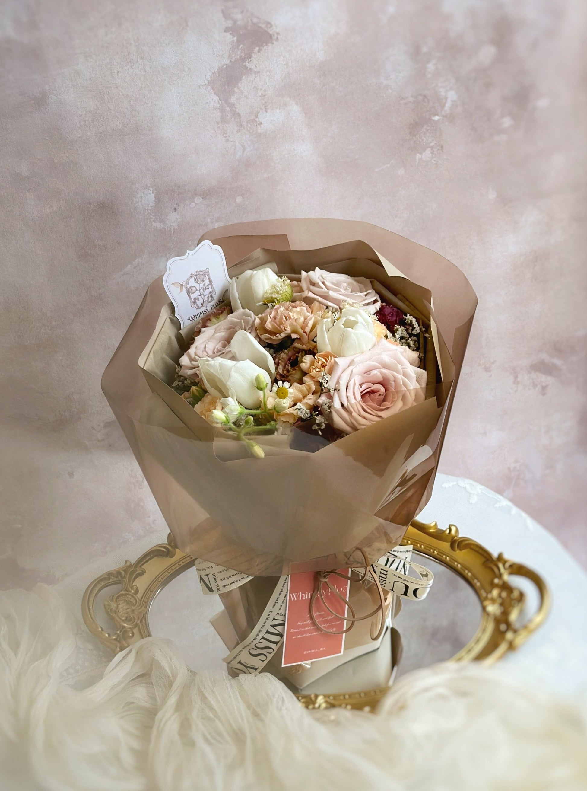  Bouquet laid flat on a table, highlighting its soft coffee-inspired tones and stylishly structured wrap — perfect under natural light.

花束平放在桌面，自然光下展现咖啡色调花材与有型包裹的优雅融合。