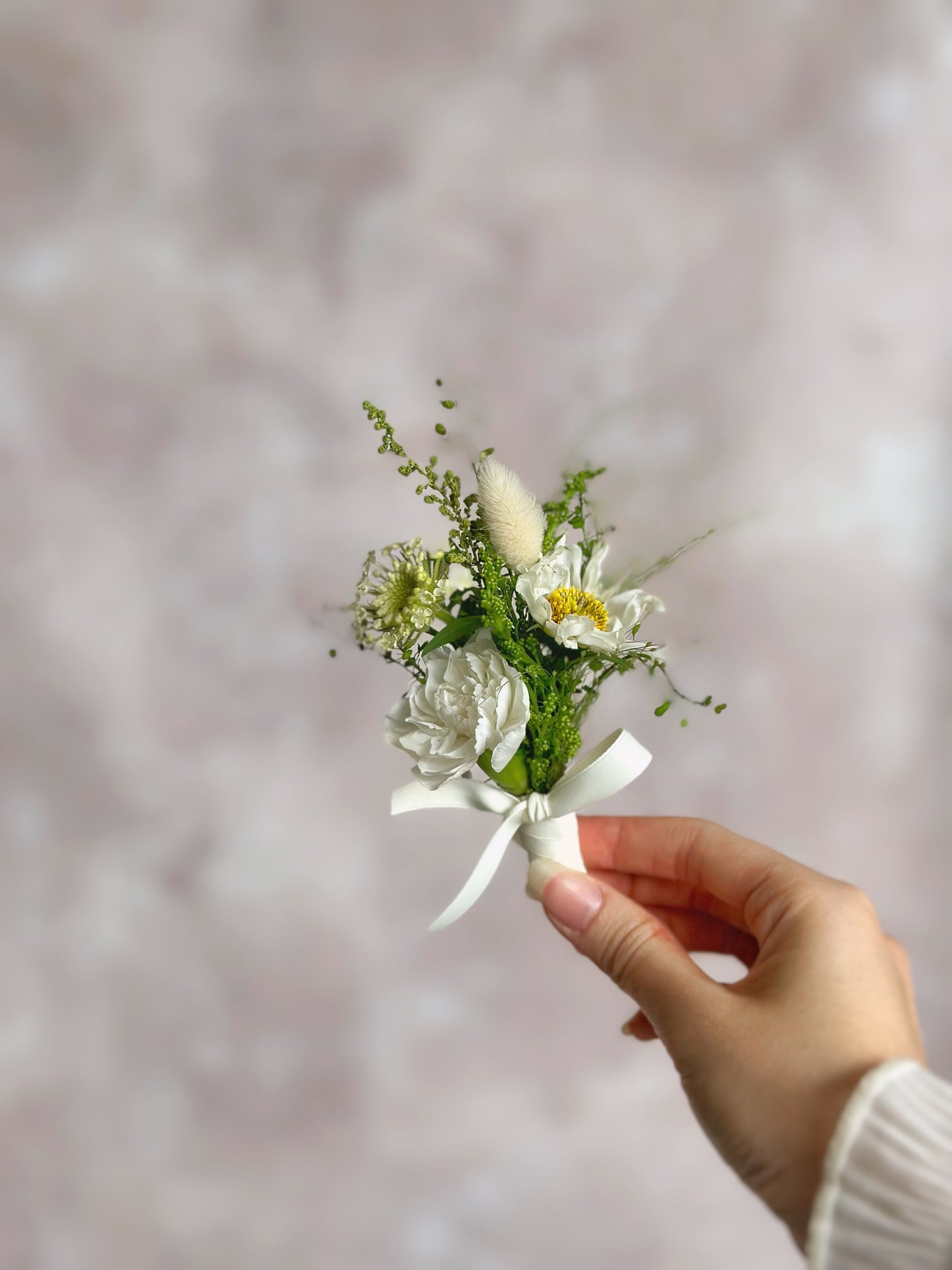 holding 'creamy meadow' fresh flowers boutonniere, front view
