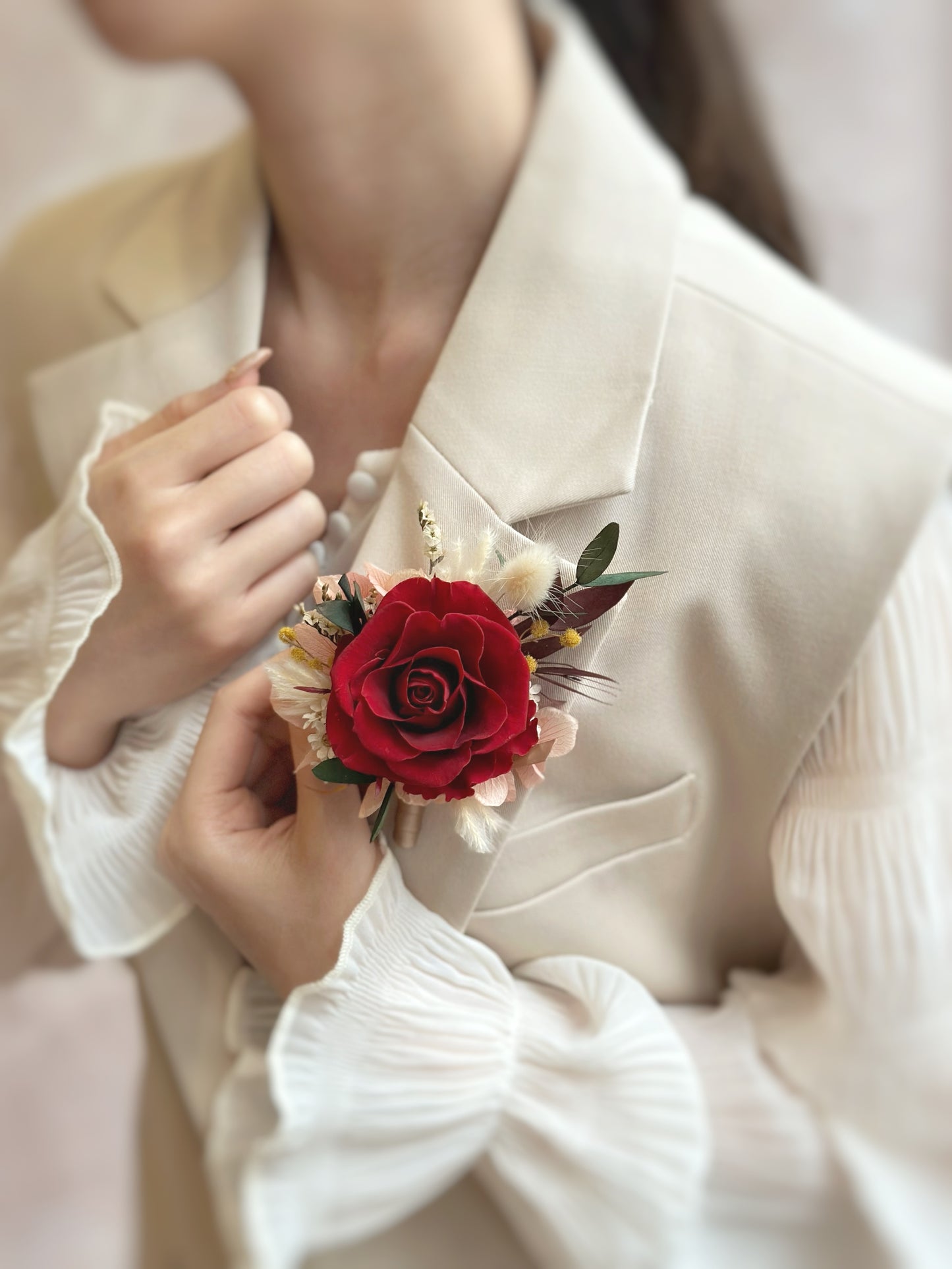 Model wearing a preserved corsage on a blazer, showcasing its elegant and timeless design