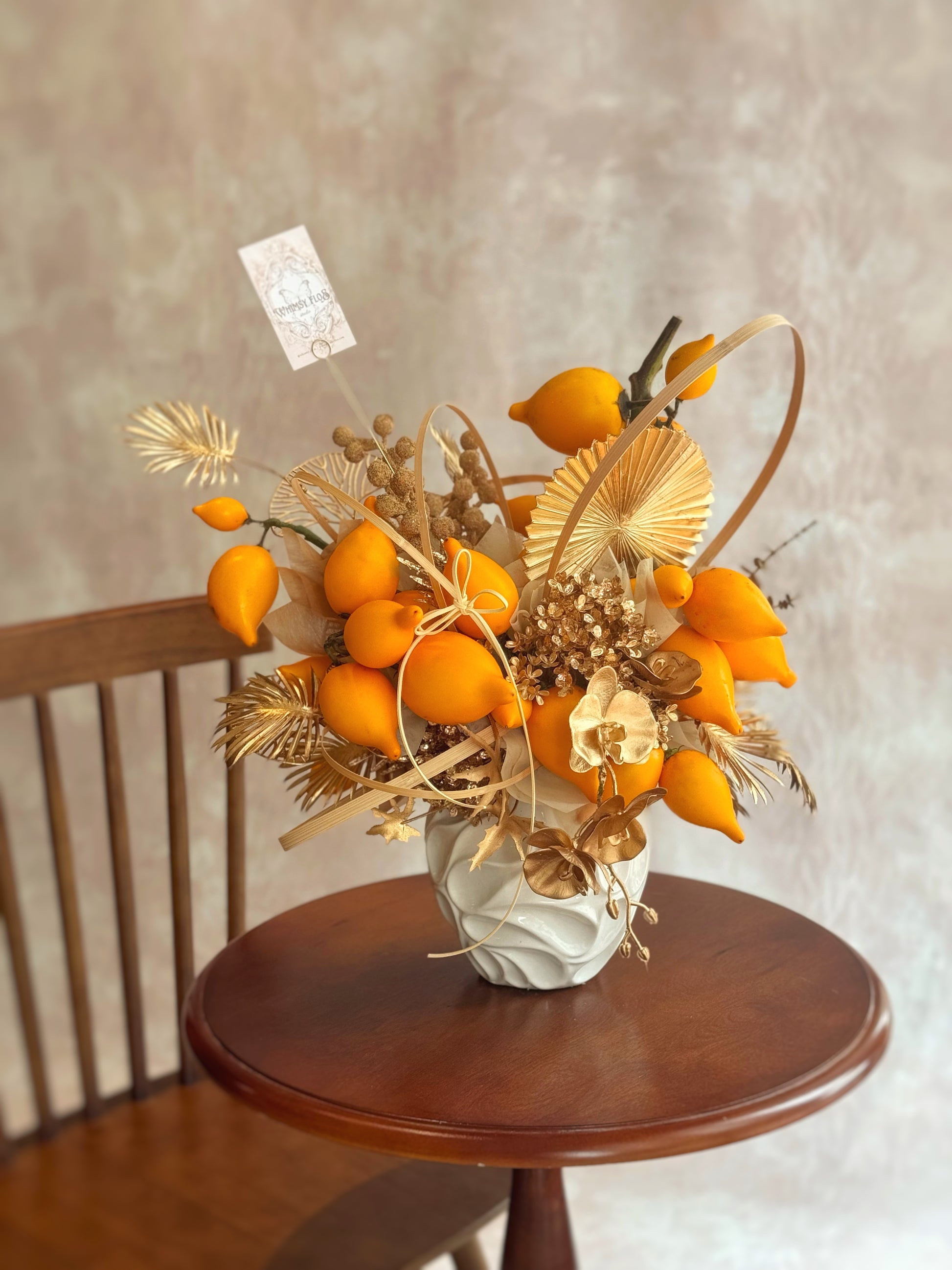 top view of cny vase arrangement, showcasing vibrant golden yellow nipplefruits.