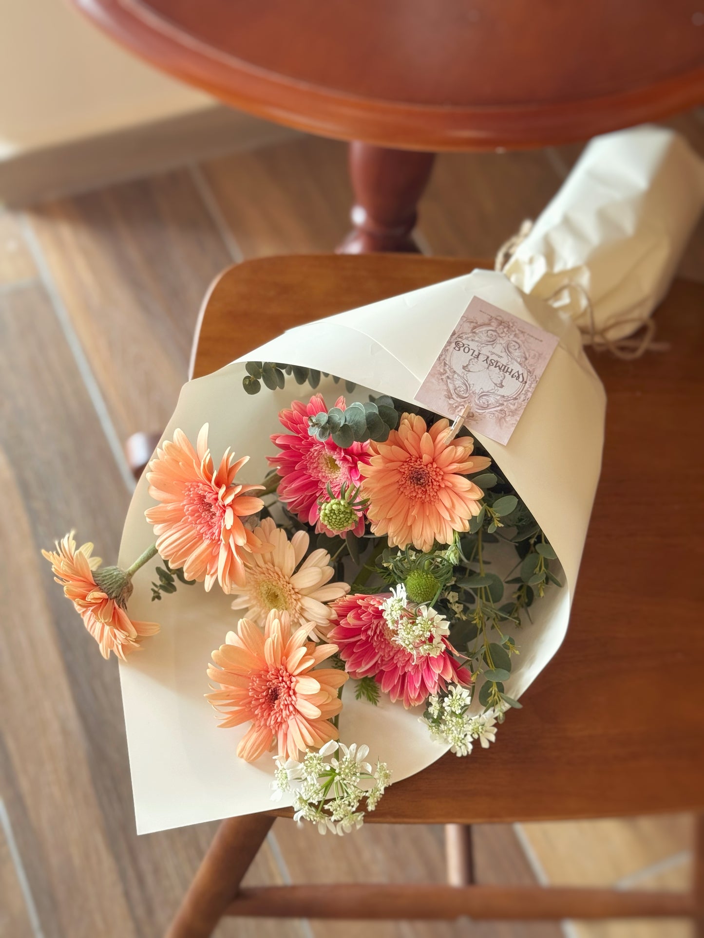Top-down view showing a burst of gerbera colors arranged in a casual, round form with natural fillers — a fresh-from-the-market feel.
俯视图展示色彩缤纷的非洲菊，搭配自然花材环绕，圆润造型营造出新鲜花市感