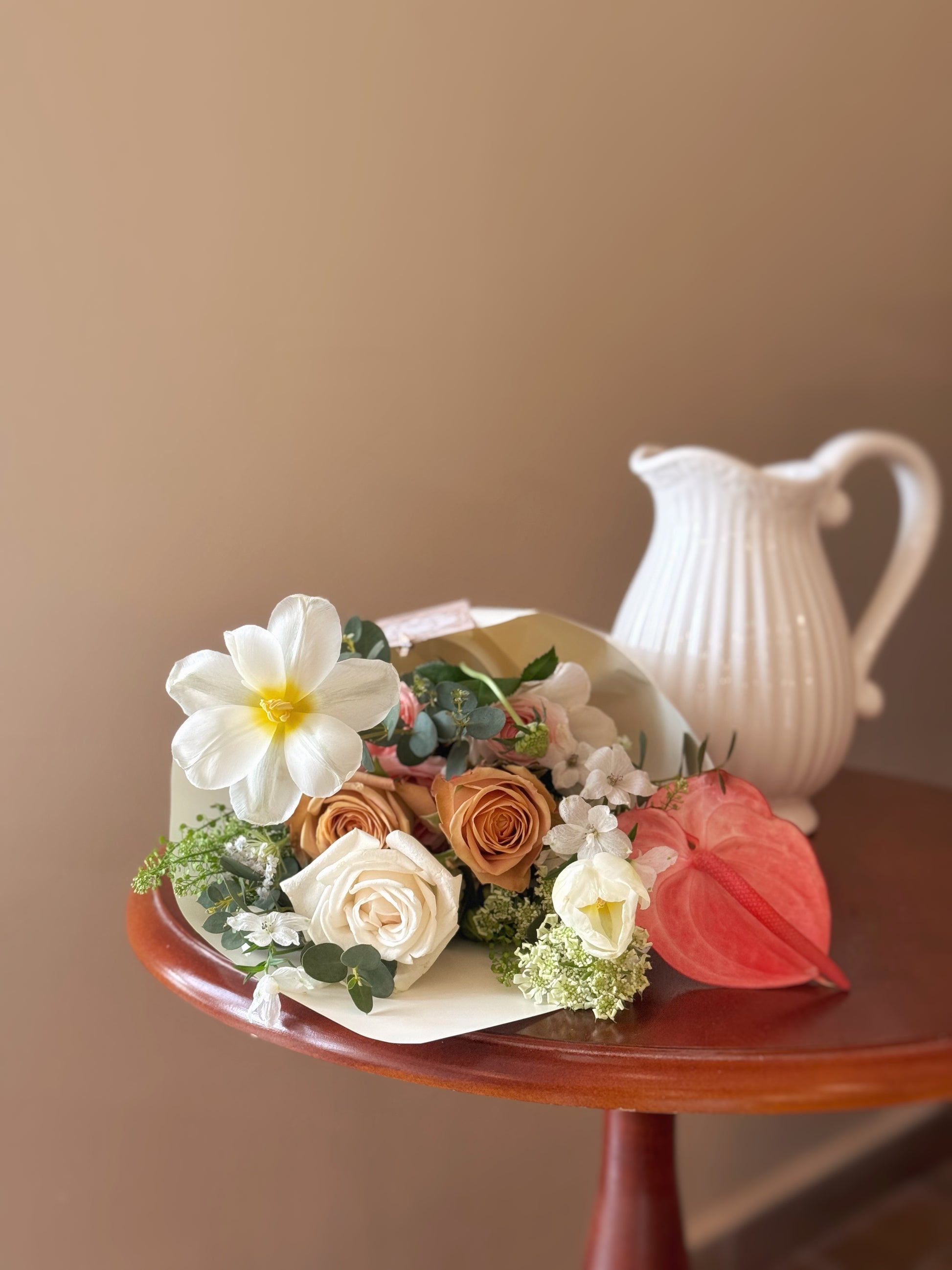 Bouquet placed on a tabletop with wrapping slightly loosened, styled as ready to go into a vase — lush yet simple.


花束平放桌面，外层包裹轻轻展开，展现蓬松自然的花型，简约却不失丰盈感。

