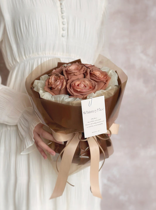 The adorable size fresh rose bouquet held in hand by a model, showcasing its warm mocha tones and romantic vintage look — perfect for date night elegance.

模特手持adorable size玫瑰花束，温暖的摩卡色调搭配复古感造型，为约会夜增添浪漫气息