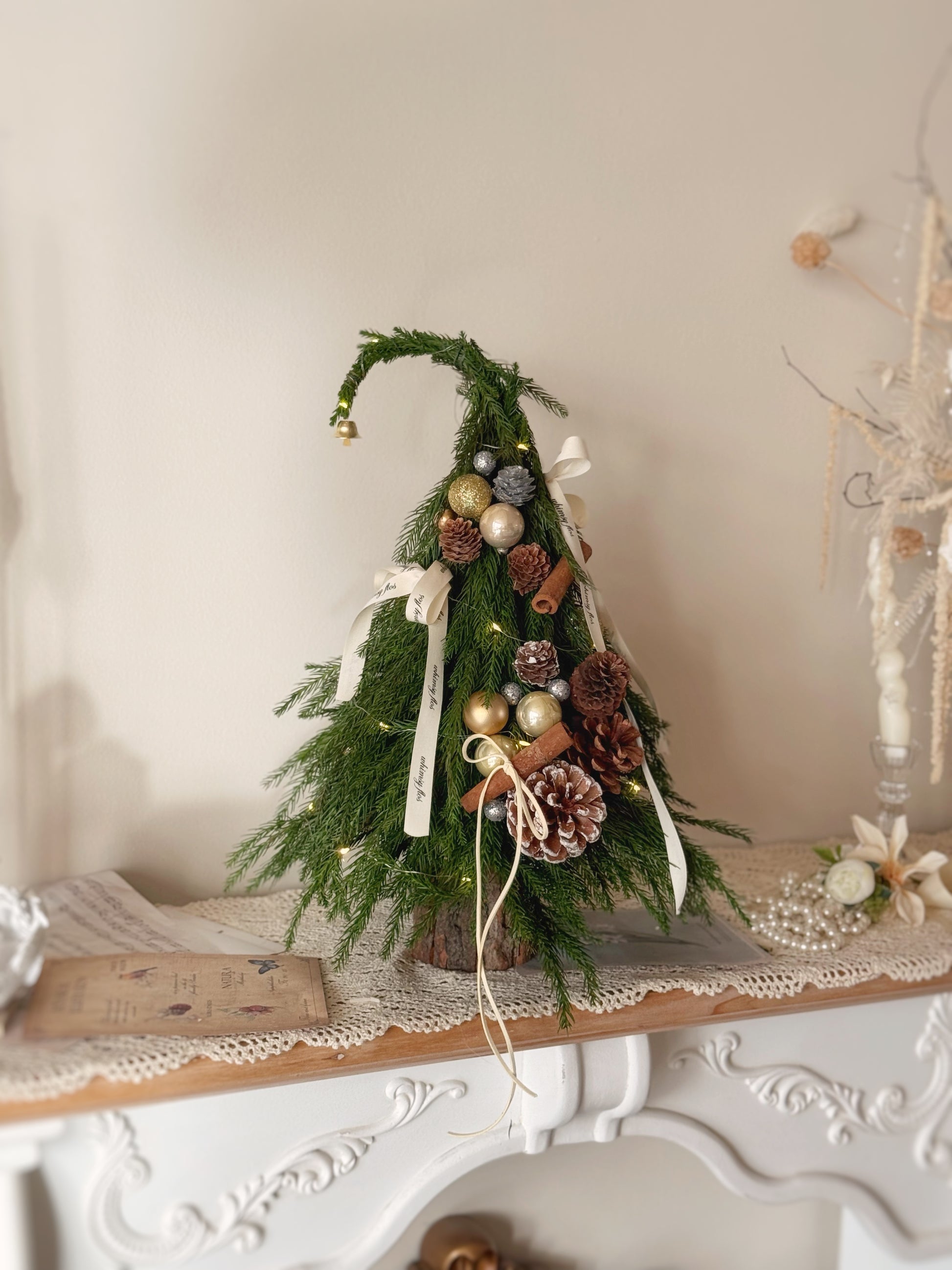 Front view of the Grinch Tree, a 38cm fresh pine Christmas arrangement with festive ornaments and LED lights.
38 厘米高 Grinch Tree 圣诞摆设正面图，配有节日装饰和 LED 灯。